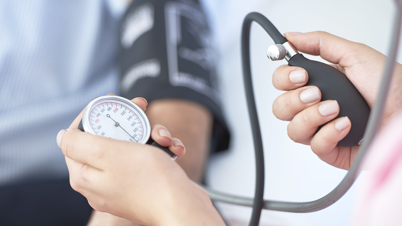person taking blood pressure of a patient